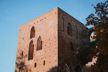 historical architecture of a medieval castle with red brick windows in autumn weather with blue sky