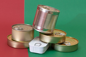 A Group of Stacked Tin Cans on Split Red and Green Background. Canned Food. Aluminum Cans for Safe and Long Term Storage of Food. Steel Sealed Food Storage Containers