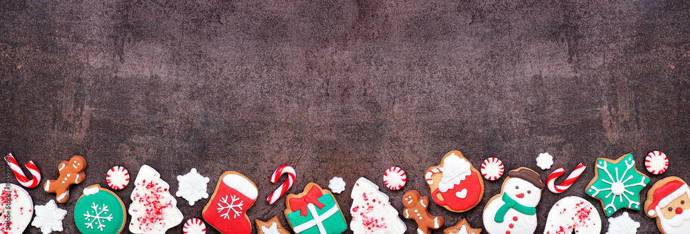 Poster fun colorful christmas cookie bottom border on a dark stone banner background with copy space. top v