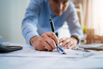 Naklejka premium A man is writing with a pen on a piece of paper. He is focused and serious, likely working on a project or task. Concept of concentration and determination, as the man puts his thoughts