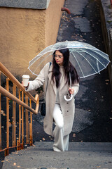 Girl with an umbrella on the stairs in rainy weather.