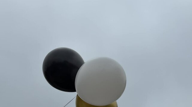 Three festive balloons moving in the wind