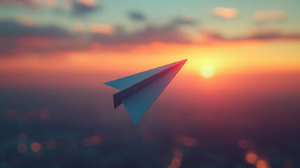 A sleek paper airplane gliding gracefully through the air against a backdrop of a serene sunset sky. 
