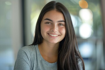 Fototapeta premium Young girl in gray shirt smiling for university photo.