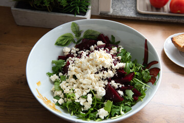 The photo shows a plate with salad, fresh herbs, beetroot and cheese.