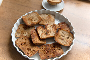 On the plate, there is toasted bread, with some pieces being burnt.