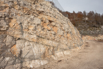 new metal nets among the woods to prevent rolling stones long a mountain slope