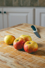 apples on a rustic wooden table with kitchen knife