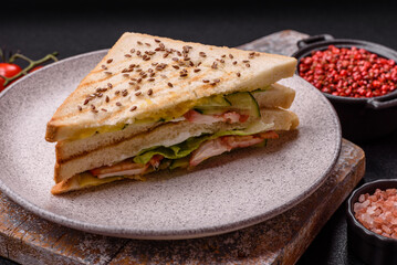 Sandwich with toast bread, meat, tomatoes, cheese, sauce, salt and spices