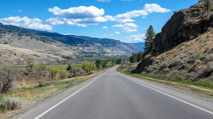Naklejka premium A serene mountain road without cars reveals stunning landscapes and vibrant skies