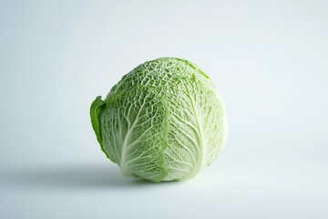 Fototapeta premium A single whole green cabbage, isolated on a white background.