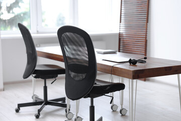 Black chairs, laptop and desk in office