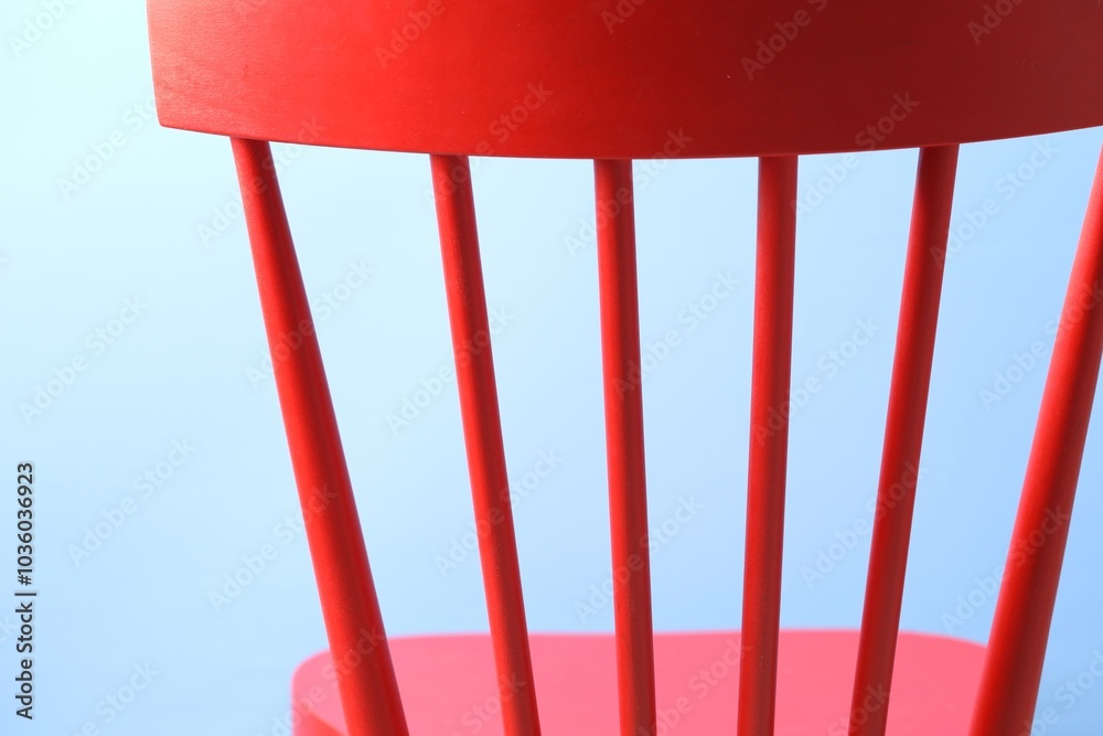 Sticker Red wooden chair on light blue background, closeup