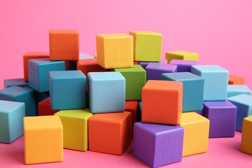 Obraz premium Many wooden colorful cubes on pink background, closeup