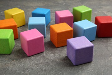 Obraz premium Many wooden colorful cubes on gray textured background, closeup