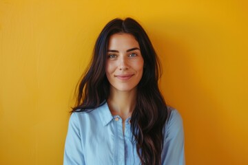 Fototapeta premium Confident Professional Woman with Long Dark Hair Against Yellow Wall for Business Profile