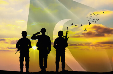 Silhouettes of soldiers with a background of the Pakistan flag and a sunset or sunrise. Concept of...