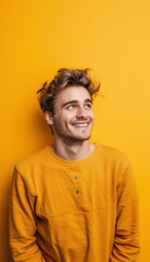 Obraz premium Playful Young Man Against Bright Yellow Background for Joyful, Lighthearted Designs