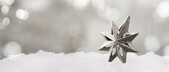christmas decoration in the shape of a star on the snow on christmas day - copy space