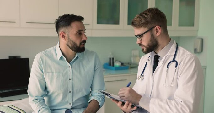 Young male patient point on chest and head talk to therapist about health complaints and symptoms, complaining of painful feelings, discomfort or chronic disease during his visit at hospital. Medicine