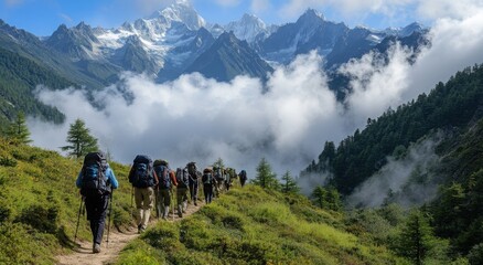 A group of hikers traverses a mountain trail with breathtaking snow-capped peaks in the distance.