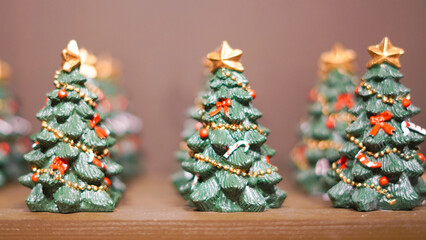 Small toy Christmas trees displayed on a showcase with festive decor
