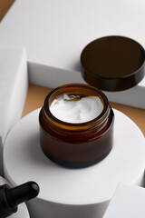 face cream on beige background on white round podium. Professional bottle for facial and body treatment. Unbranded package