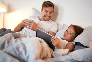 Bedtime, storytelling on tablet and dad with son in home at night for bonding, education or reading. App, ebook or social media with happy family of single parent man and boy child in bed together