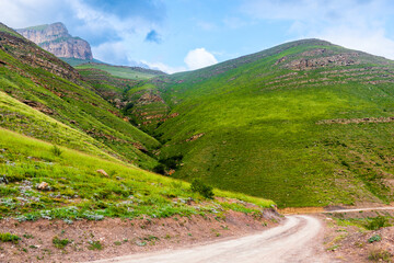 Mountain dirt road among picturesque green mountains. Caucasus