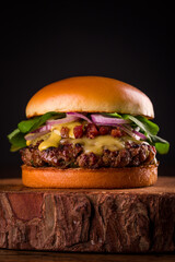 Delicious Gourmet Burger with Cheese and Fresh Toppings on Wooden Board