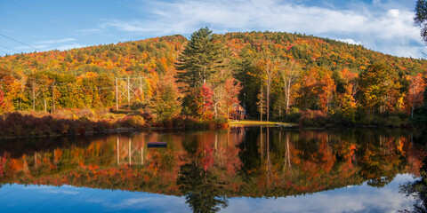 Panoramic view of colorful trees by the lake rescue in Vermont countryside.