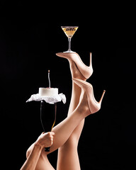 Female legs in high heels holding a full glass, hands holding a cake Concept of balance, celebration