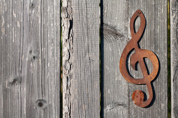 Background and texture of rustic wooden slats lying next to each other. A rusty metal clef is attached to one of the wooden slats.