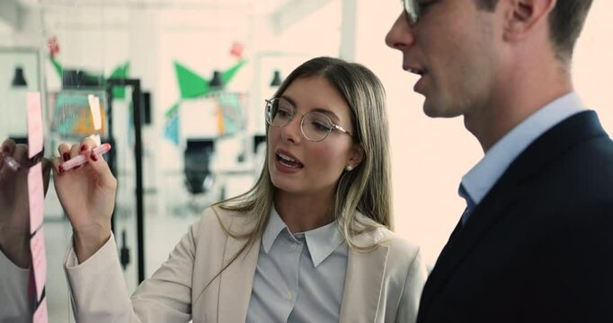 Teammates working together using sticky notes, collaborate, organizing, creating to-do list, brainstorming ideas, giving high five, successfully completed task, reached joint goals. Effective teamwork