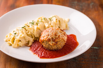 Delicious Meatball and Creamy Pasta Dish on a White Plate