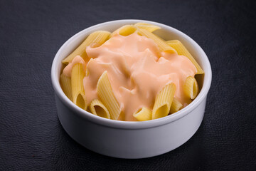 Delicious Creamy Pasta Dish in a White Bowl on Dark Background