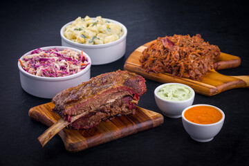 Delicious Barbecue Meal with Ribs, Coleslaw, and Creamy Sauces