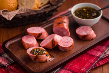 Sliced Grilled Sausages on a Wooden Tray with Herb Garnish