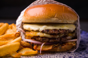 Close-Up of Juicy Cheeseburger With Crispy Fries on Plate
