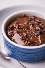 Rich Chocolate Pudding in Blue Bowl with Cacao Nib Topping