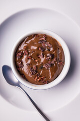 Creamy Chocolate Dessert Topped with Cocoa Nibs in White Bowl