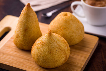 Golden Brazilian Coxinhas on a Wooden Cutting Board