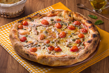 Delicious Homemade Pizza with Fresh Tomatoes and Basil on Wooden Table