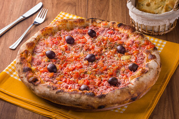 Delicious Italian Pizza with Olives and Fresh Tomatoes on Table