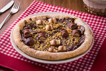Delicious Chocolate Dessert Pizza with Nut Topping on Table
