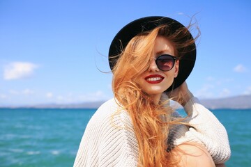 Autumn portrait of happy smiling young woman wearing a sweater and hat. 