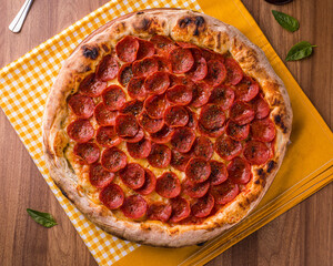 Delicious Pepperoni Pizza on a Wooden Table with Basil Leaves