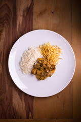 Delicious Brazilian Stroganoff with Rice and Potato Sticks on Plate