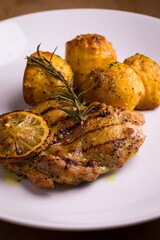Grilled Chicken Breast with Roasted Potatoes and Lemon Garnish
