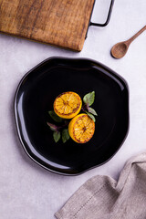 Elegant Culinary Presentation of Grilled Lemons on Black Plate